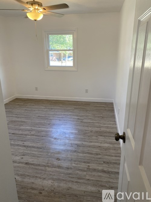 A room with a wooden floor and a ceiling fan.
