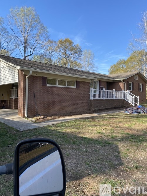 A house with a white fence and a car parked in front.