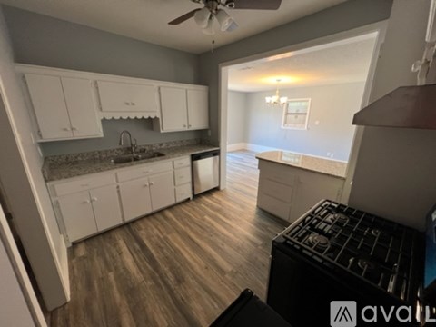 A kitchen with white cabinets and a black stove top oven.