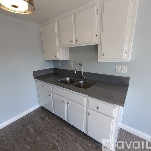 A kitchen with white cabinets and a sink.