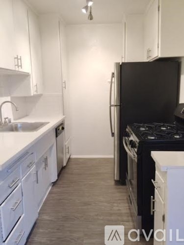 A kitchen with white cabinets and a black stove top.