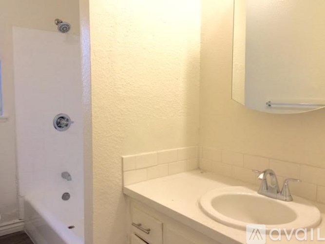 A white bathroom with a sink and a mirror.