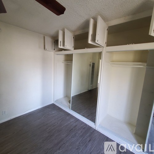 Empty room with white walls and wood flooring.