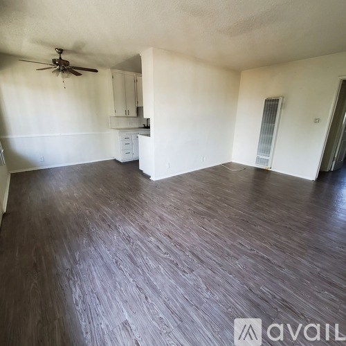 A room with wooden flooring and a ceiling fan.