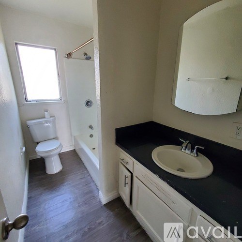 A bathroom with a toilet, sink, and mirror.