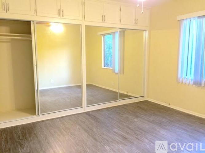 A room with a window and a wooden floor.