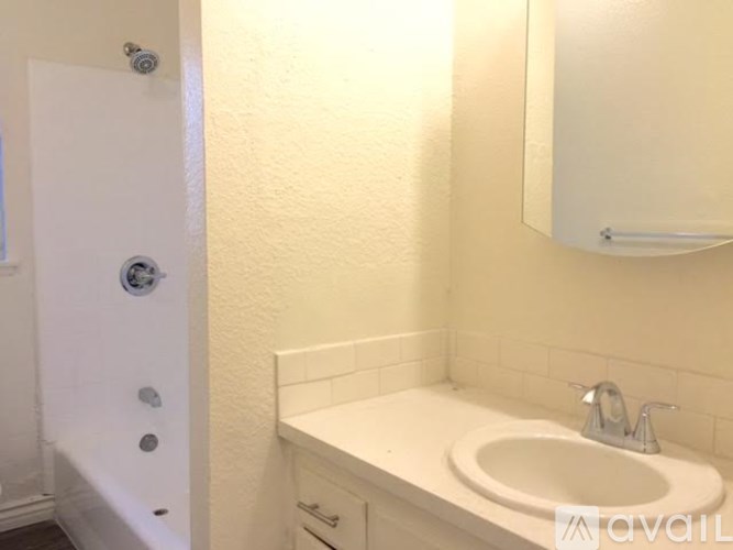 A white bathroom with a sink and a mirror.