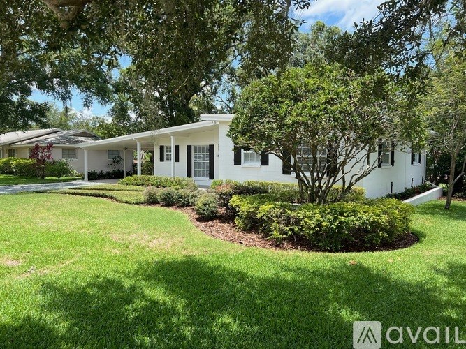 A white house with a tree in front of it.