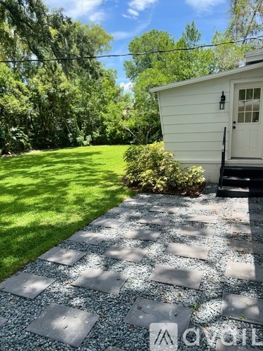 A white house with a grey stone pathway leading to the front door.