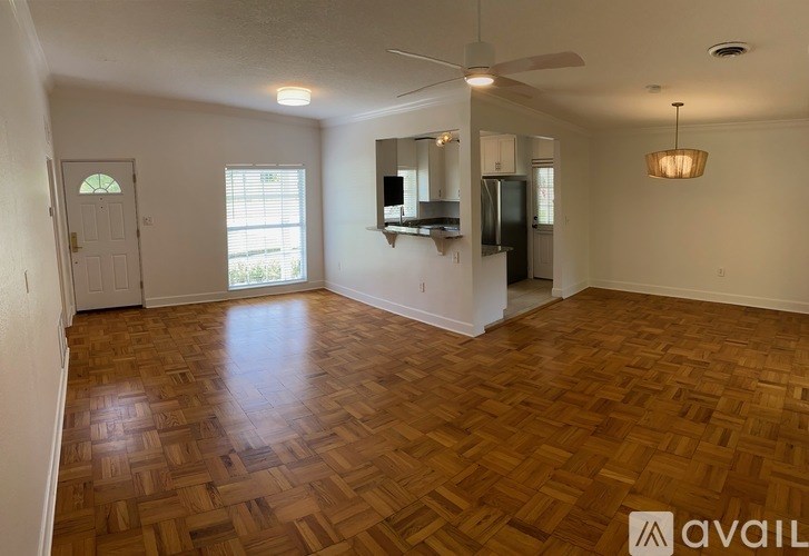 A room with wooden flooring and a ceiling fan.