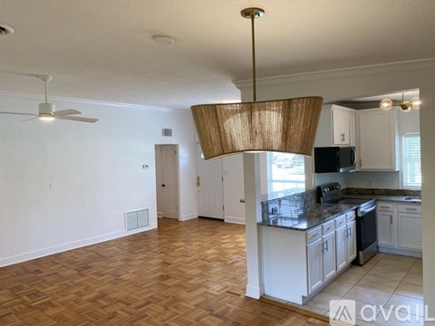 A living room with a kitchen in the background.