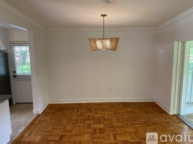 A room with wooden flooring and a hanging light fixture.