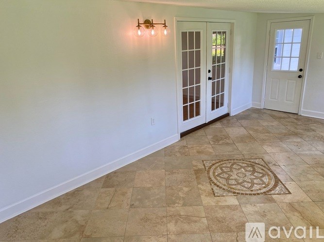 A room with a tiled floor and a rug in the middle.