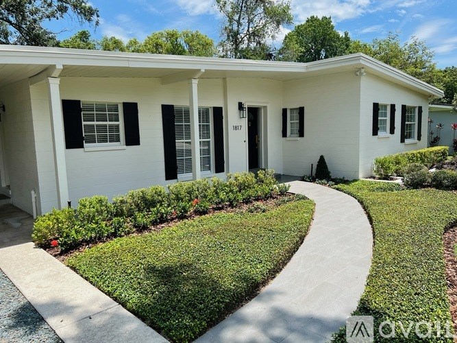 A white house with black shutters and a black door.