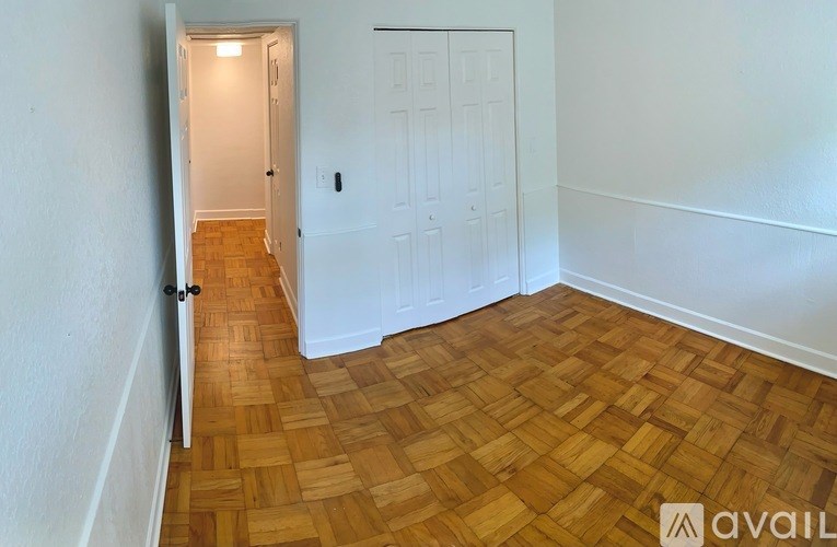 A room with a wooden floor and a white door.