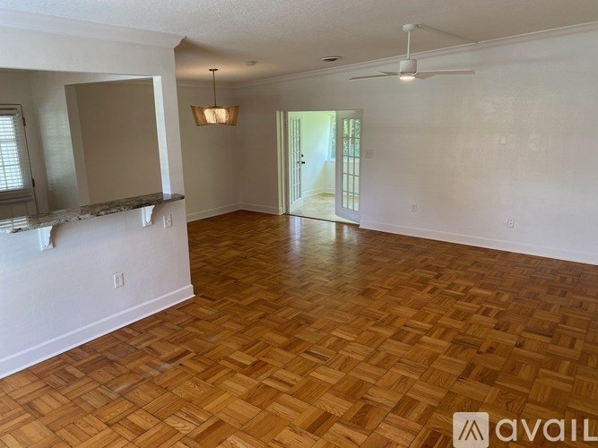 A room with wooden flooring and a ceiling fan.
