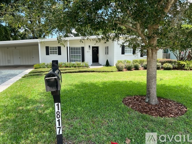 A white house with a black mailbox numbered 1817.