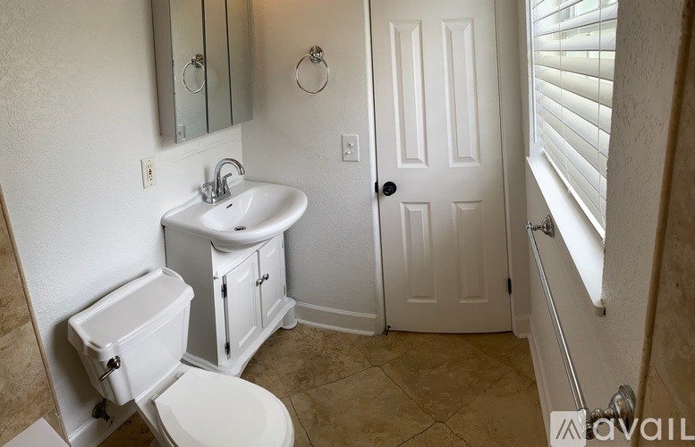 A bathroom with a toilet, sink, and medicine cabinet.