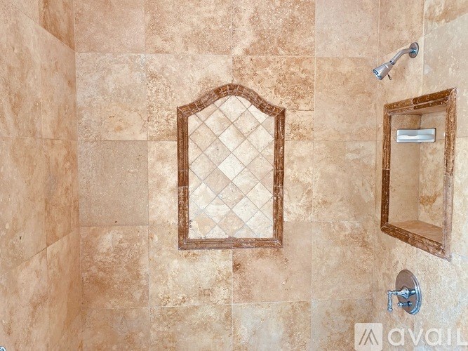 A bathroom with a tiled wall and a mirror.