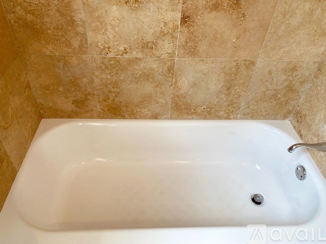 A white bathtub with a faucet is in the bathroom.