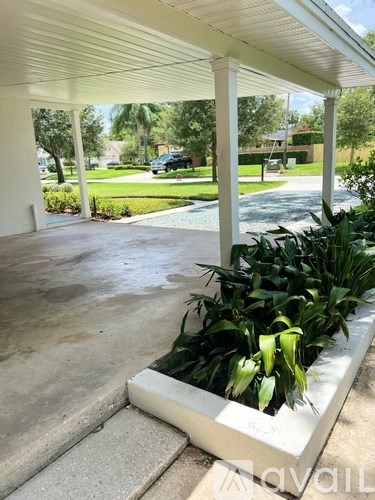 A white porch with a planter box on the steps.