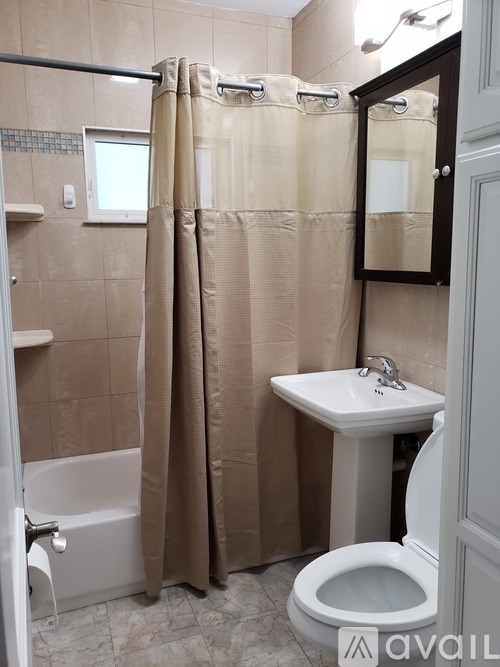 A bathroom with a toilet, sink, and shower curtain.