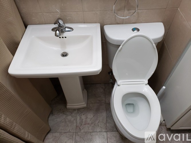A white toilet with a sink in a small bathroom.