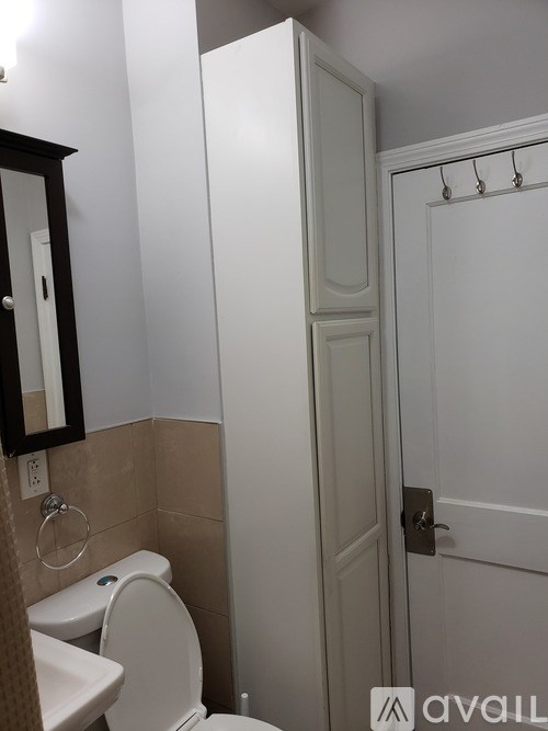 A white toilet sits next to a white sink in a bathroom.