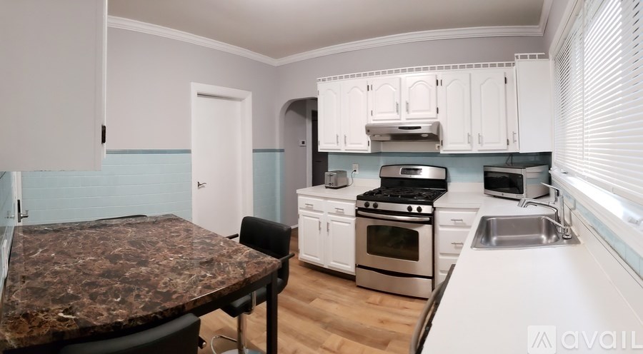 A kitchen with a granite countertop and stainless steel appliances.