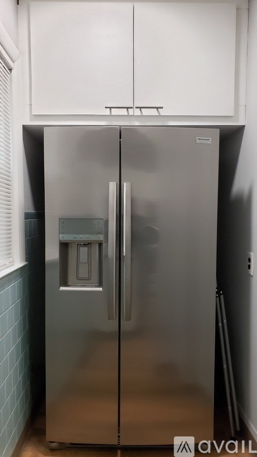 A stainless steel refrigerator with a water and ice dispenser in the middle of the door.