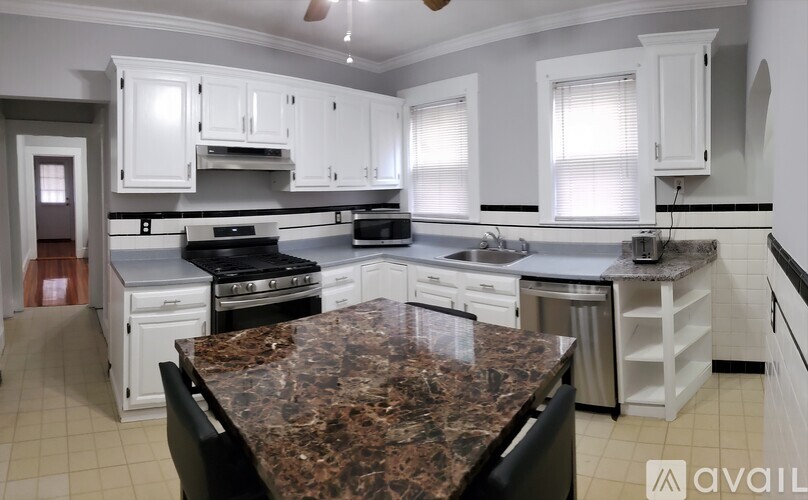 A stainless steel oven with a digital display is installed in a kitchen.