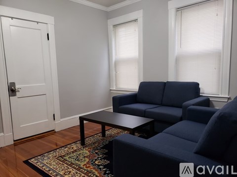 A living room with a blue couch and a coffee table.