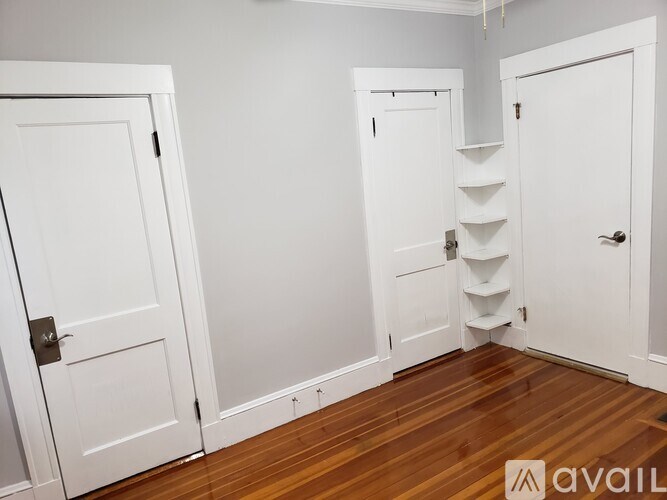 A room with white doors and a wooden floor.