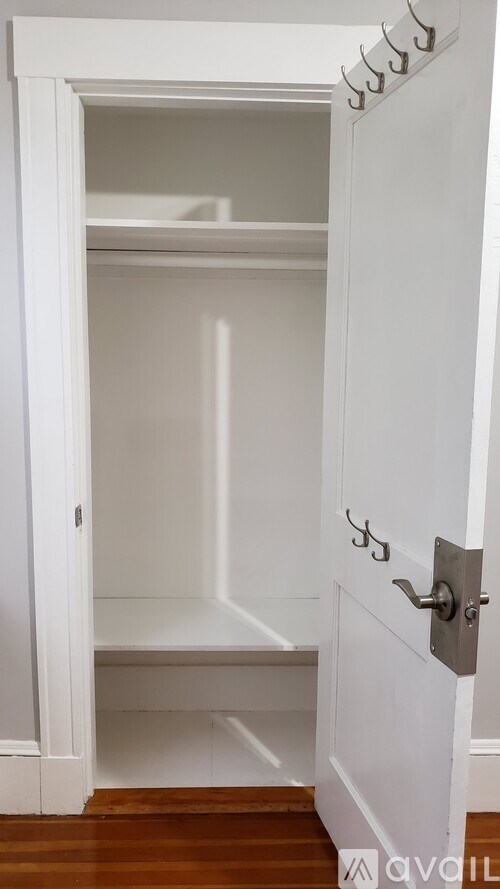 A white door with a silver handle is open.