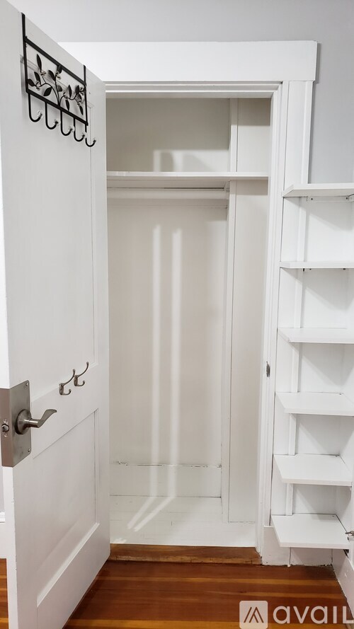 A white door with a handle and a small shelf underneath it.