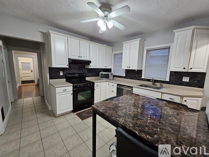 A kitchen with a table and chairs in the middle of it.