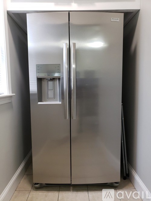 A stainless steel refrigerator with a water and ice dispenser in the middle of the door.