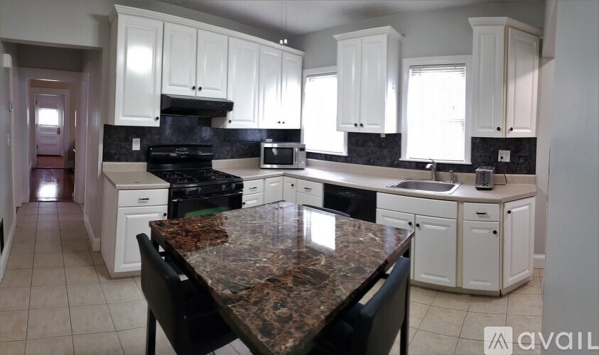 A kitchen with granite countertops and white cabinets.
