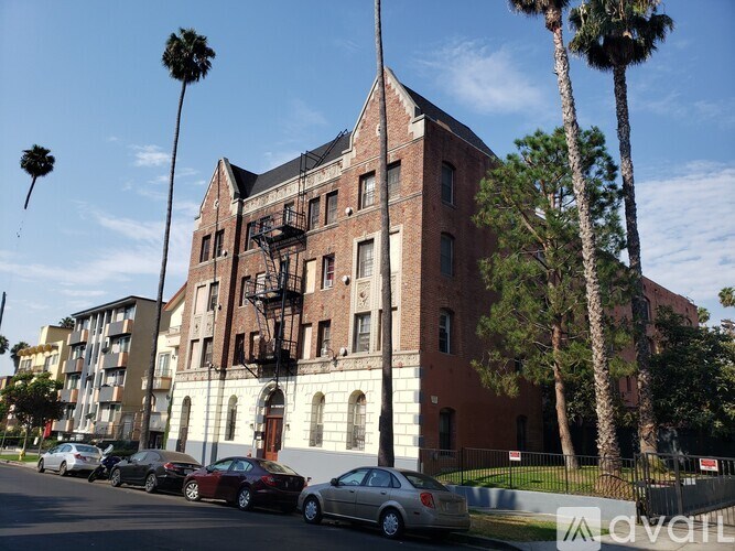 A tall red brick building with a black fire escape on the side.