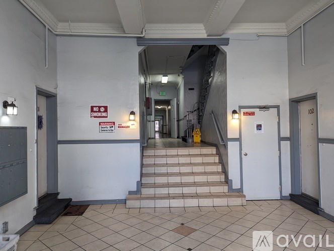 A hallway with a staircase and a no smoking sign.