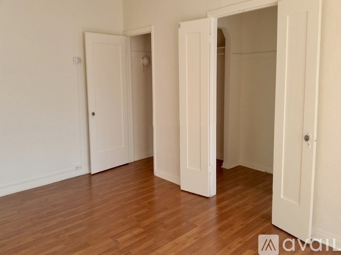 Three white doors in a room with wooden floors.