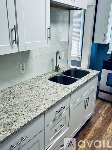 A kitchen with granite countertops and white cabinets.