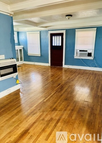 A room with wooden floors and a blue wall.