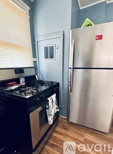 A kitchen with a black stove top and a silver refrigerator.