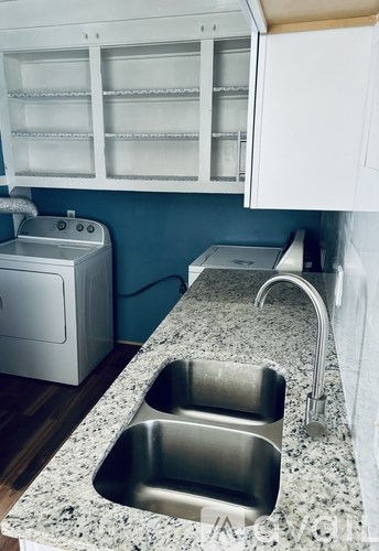A kitchen with a granite countertop and stainless steel sink.
