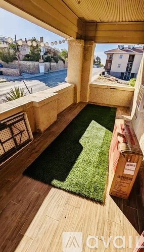 A balcony with a green artificial grass area and a wooden floor.