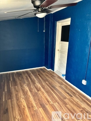 A room with wooden flooring and a ceiling fan.