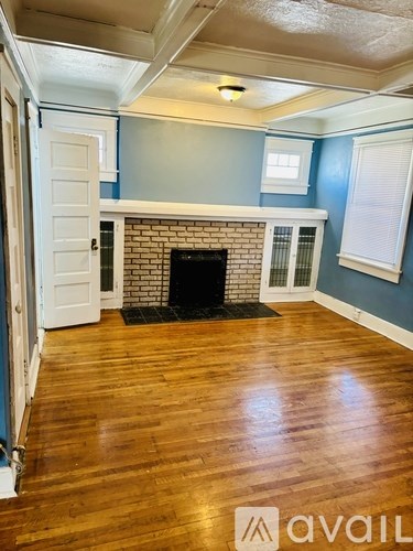 A room with a fireplace and wooden floors.