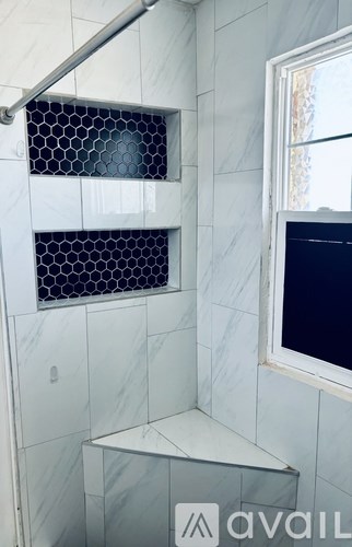 A shower area with a glass door and a window.