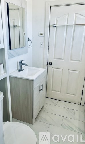 A bathroom with a sink, toilet and mirror.
